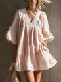 Close-up detail of white lace trim on the V-neckline of a pink tiered resort summer dress - Pink
