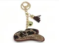 Porte-clés en forme de chapeau de cow-boy avec strass brillants, clochette et pompon marron - Sombrero à Franges