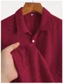 Close-up of burgundy knit polo shirt with vertical textured pattern and white button. - S / Tops / Red