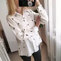 Mirror selfie showing the swallow print detail on a white linen casual shirt for women - S / Tops / White Floral Print