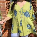 Close-up of a lime green floral print cotton linen V-neck blouse with decorative buttons. - S / Tops / Yellow