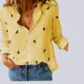 Close-up of a casual yellow linen shirt featuring black bird prints and a comfortable V-neckline - S / Tops / Yellow Floral Print