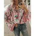 Close-up of bohemian pink floral peacock print blouse showing bell sleeves and buttons. - S / Tops / Pink