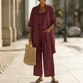 Detail showing a burgundy three-piece linen-style set in a sunny urban street setting - Dark Red