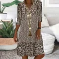 Gedetailleerd overzicht van een bruine bloemen midi-jurk met V-hals en elegante kwastjesketting - S / Dresses / Bruin