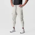 Detail of men's athletic cargo joggers with multi-pocket design in light grey - White