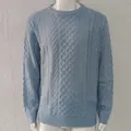 Close-up of a blue men's cable-knit sweater featuring intricate textured patterns - Blue