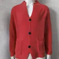 Close-up view of men's coral orange knit cardigan with waffle texture and black buttons - Pink