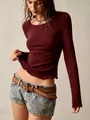 Close-up detail of slim-fit textured long sleeve top with delicate lettuce edge hem. - S / Tops / Burgundy