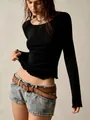 Detailed view of women's black long sleeve top featuring ribbed knit and lettuce edge hemline - S / Tops / Black