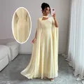 Elegant cream evening gown with cape sleeves and lace-up back detail for formal parties. - S / Dresses / Light Yellow