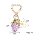 Detailed product shot of a translucent purple strawberry keychain with a daisy charm - Purple Strawberry Heart Hook + Accessories