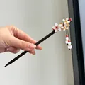 Detailed view of handmade Chinese wooden hairpin with floral accents and tassel - Spring Breeze Style (FZ24077)