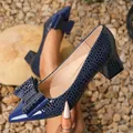Close-up of navy blue crocodile-patterned block heel pumps with an elegant bow detail. - 36 / Navy Blue