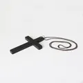Detailansicht eines minimalistischen schwarzen Kreuzanhängers mit dunkler Metallkugelkette. - Kreuz-Halskette