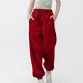 Vooraanzicht van rode baggy joggingbroek voor kinderen, toont losse pasvorm en manchetten. - Rood