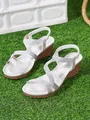 Close-up detail of stylish silver bohemian wedge sandals for women on green grass - 36 / Silver