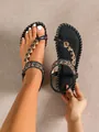 Detailed view showing the intricate beading on black Bohemian style flat thong sandals - Graphite Black
