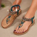 Dettaglio dei sandali infradito boho turchesi con strass sulla spiaggia di sabbia - 36 / Verde Scuro