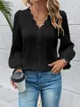 Detail view of black long-sleeve blouse with lace V-neck and ruffled bell sleeves. - Black
