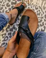 Detailed view of black vintage toe-ring flat sandals on a leopard print rug - 35 / Black