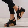 Detail view of women's black platform wedge sandals with rivet accents and cork texture soles. - 35 / Black