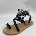 Detail view of navy blue floral lace straps on bohemian flat sandals - 38 / Black