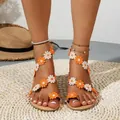 Detail view of Bohemian flat sandals with vibrant orange and white daisy floral embroidery. - Yellow Floral