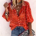 Close-up of women's orange polka dot shirt with white buttons and V-neckline - S / Tops / Red