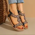 Detailed view of bohemian flat sandals with intricate beadwork and circular patterns. - 36 / Black