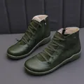 Macro view of stylish green leather casual ankle boots featuring cross-lace design and zipper - Green