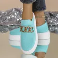 Close-up of teal knit slip-on sneakers with chunky white sole and gold chain detail - Lake Blue