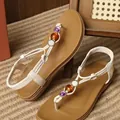 Detailed view of bohemian flat sandals with white straps and colorful decorative beads - 36 / White