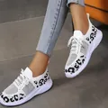 Detailed view of women's white knit sneakers with leopard print pattern worn with denim jeans - 35 / White Black
