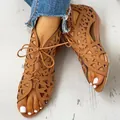 Close-up of fashionable brown cutout lace-up wedge sandals worn on feet with white nails - 36 / Dark Brown