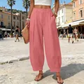 Detailed view of pink high-waisted harem pants captured in a summer street style setting - Rose