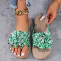 Gedetailleerde close-up van damesstrandsandalen met levendige groene tropische bloemen - Grasgroen