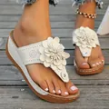 Close-up of white platform thong sandals featuring a large 3D flower decoration - Off White