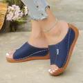 Nahaufnahme von marineblauen Plateau-Pantoletten mit eleganten weißen Ziernähten. - 36 / Dunkelblau
