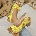 Detail of yellow laser-cut floral sandals with chunky heels and peep toe design - Yellow