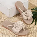 Detailopname van elegante beige dames strandsandalen met stijlvolle bloemdecoratie - Abrikoos