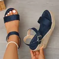 Macro view of navy blue suede wedge sandals featuring a braided rope platform heel. - Navy Blue