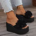 Chic black platform wedge slippers featuring an oversized flower and woven sole - Black