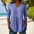 Blue and white gingham V-neck top with ruffled peplum hem shown on a model at beach - Blue