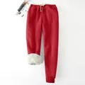 Detail of red women's sweatpants with warm white fleece lining and drawstring waist. - S / Bottoms / Red