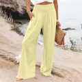 Dettaglio dei pantaloni larghi gialli a vita alta in lino da donna sulla spiaggia. - Taglia S / Pantaloni e gonne / Giallo