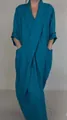Detail view of a teal blue V-neck maxi dress with large side pockets and rolled sleeves. - Blue