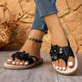 Détail des sandales noires bohèmes avec un ornement de fleurs et des brides tressées - 36 / Noir