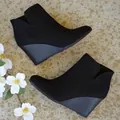 Close-up of black suede wedge ankle boots with elegant side V-cut on stone tiles - 35 / Black