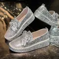 Detailed view of silver glitter loafers with rhinestone bows and 4cm platform. - 35 / Silver